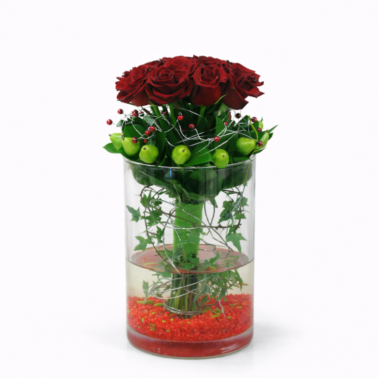 Σύνθεση με κόκκινα τριαντάφυλλα και διακοσμητικά πράσινα μήλα σε γυάλινο vase